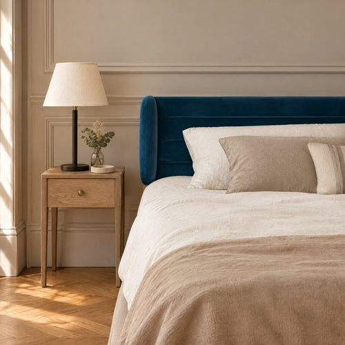 Tête de lit à oreilles en velours ligné Chaillot bleu canard dans une chambre, avec table de chevet et lampe