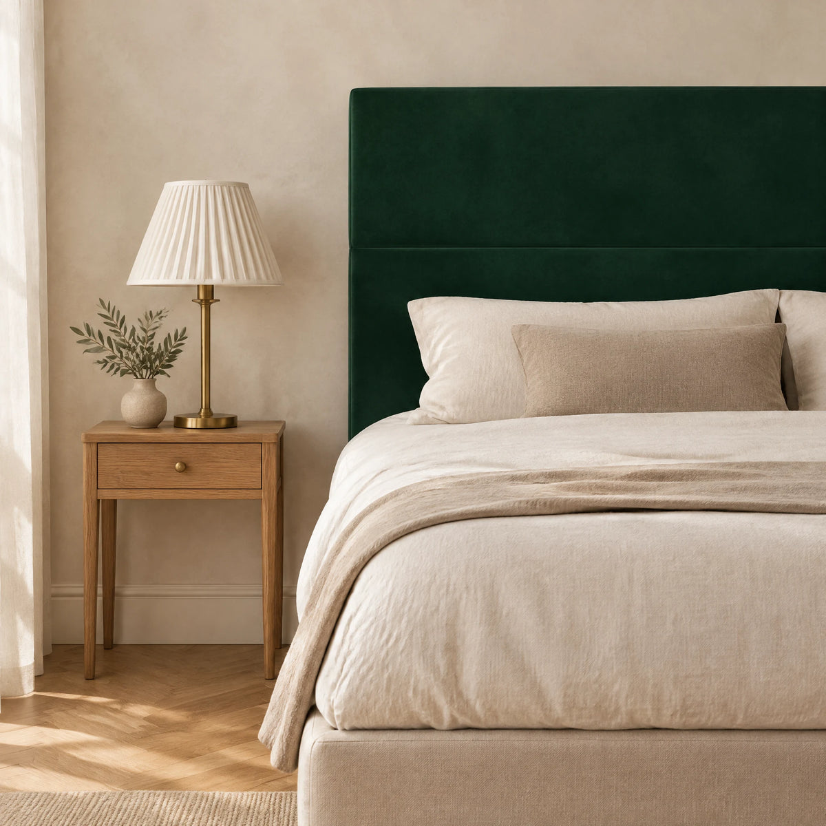 Tête de lit haute en velours lisse Châtelet vert sapin dans une chambre, avec table de chevet et lampe