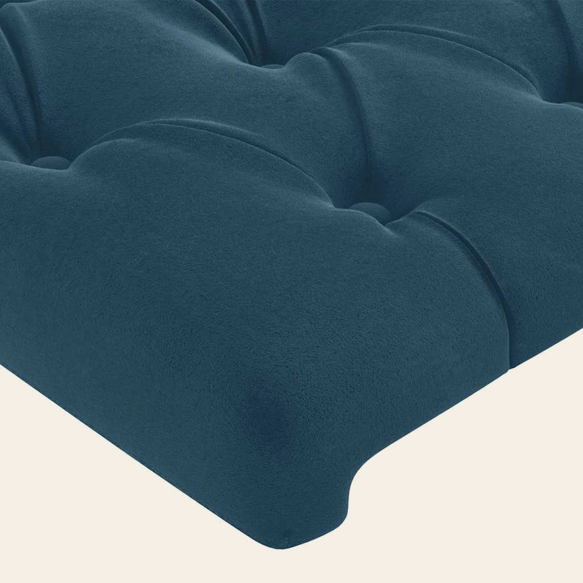 Gros plan du velours capitonné bleu canard de la tête de lit Montaigne