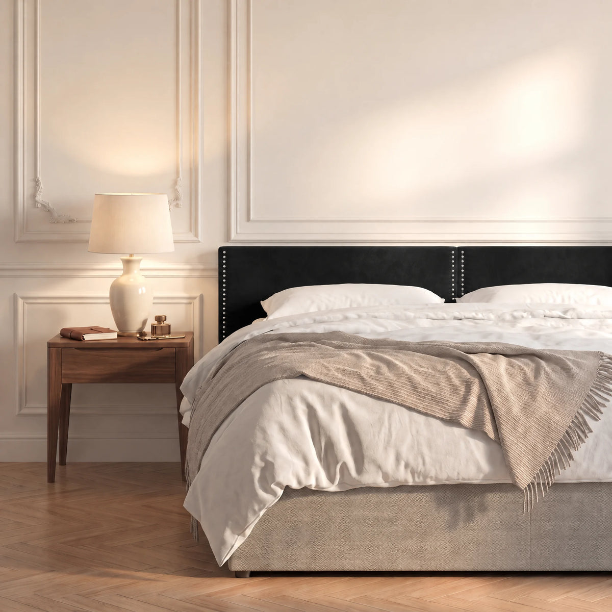Tête de lit cloutée en velours à poser Saint-Louis noir dans une chambre, avec table de chevet et lampe