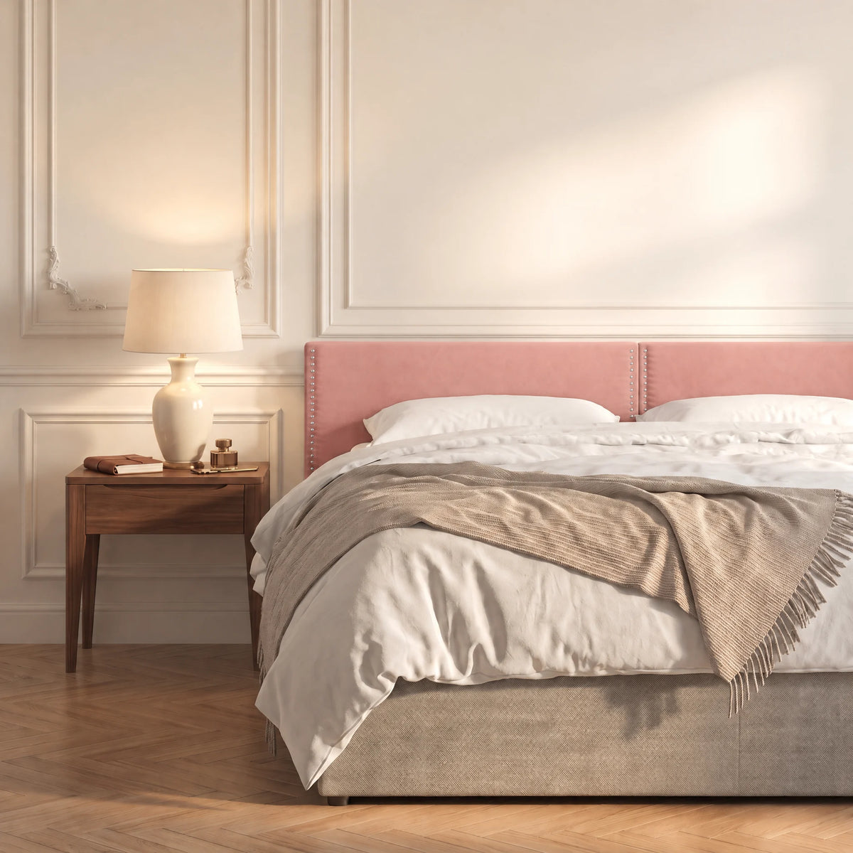 Tête de lit cloutée en velours à poser Saint-Louis rose poudré dans une chambre, avec table de chevet et lampe