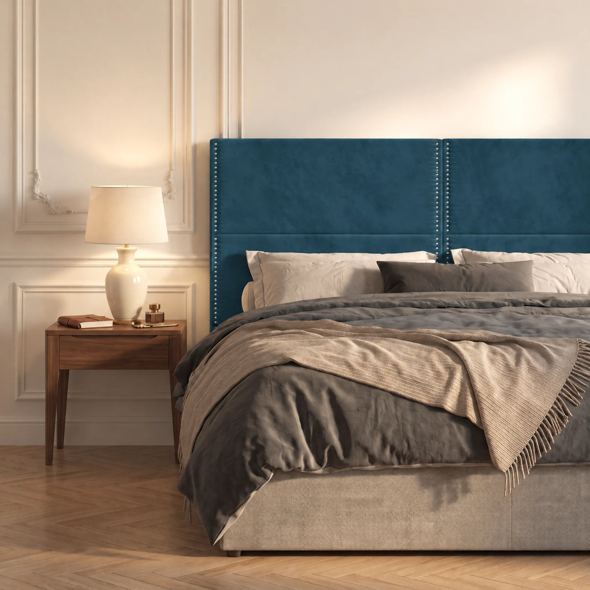 Tête de lit haute cloutée en velours Matignon bleu canard dans une chambre, avec table de chevet et lampe