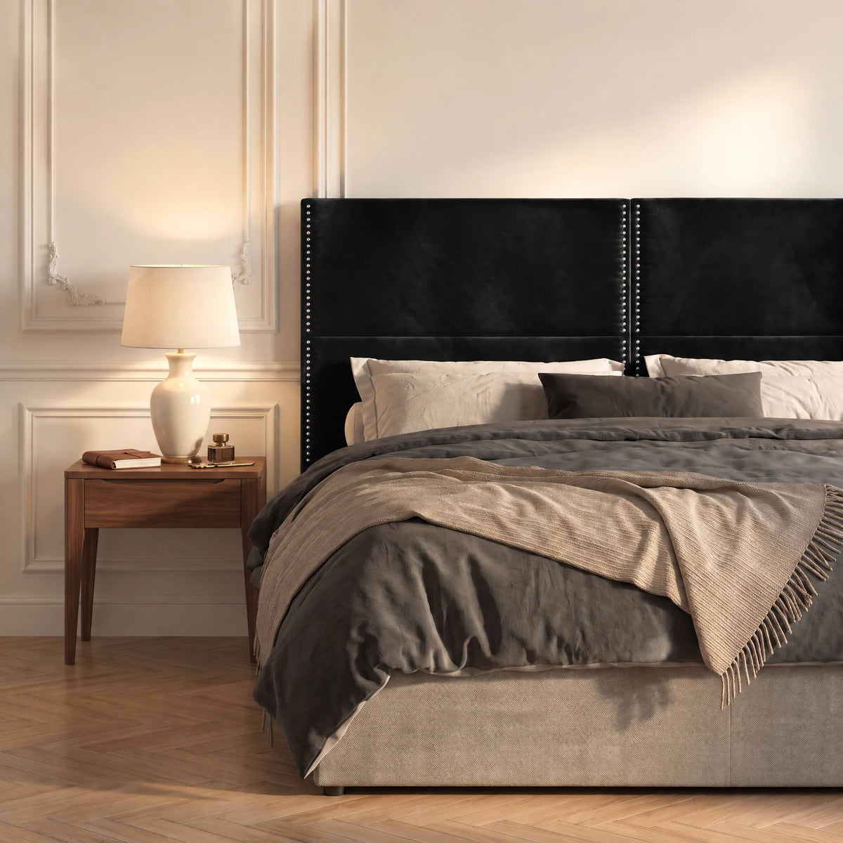 Tête de lit haute cloutée en velours Matignon noir dans une chambre, avec table de chevet et lampe