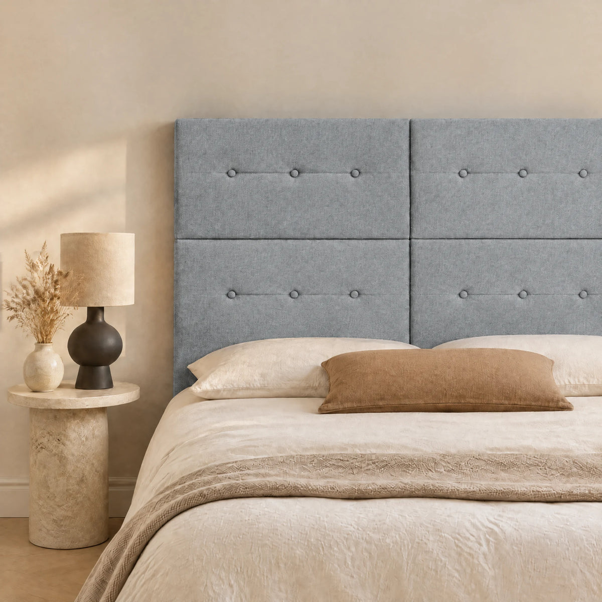 Tête de lit haute en tissu Bastille gris clair dans une chambre, avec table de chevet et lampe