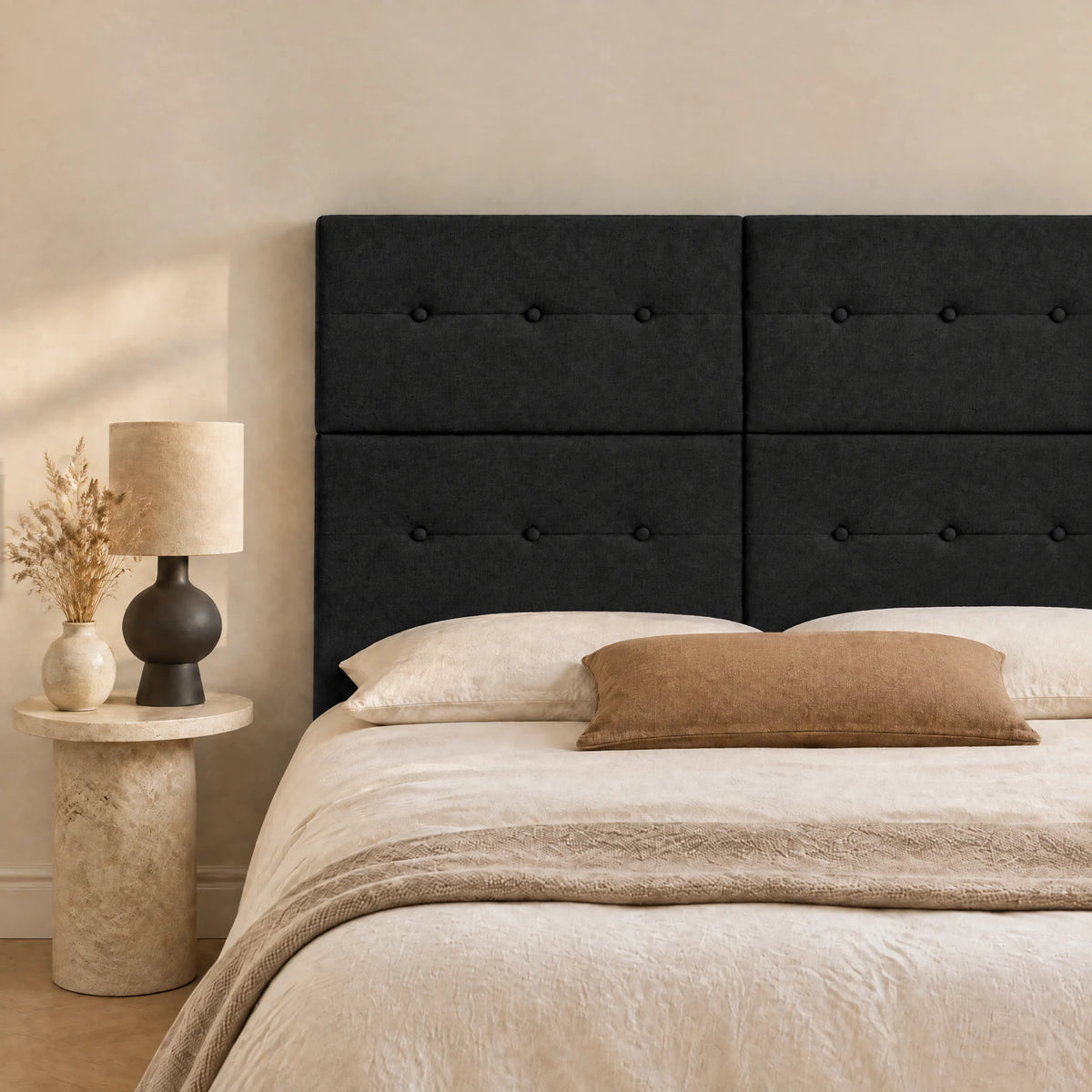 Tête de lit haute en tissu Bastille noir dans une chambre, avec table de chevet et lampe