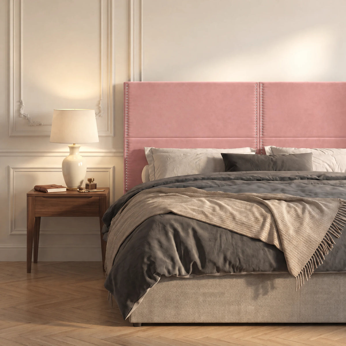 Tête de lit haute cloutée en velours Matignon rose poudré dans une chambre, avec table de chevet et lampe