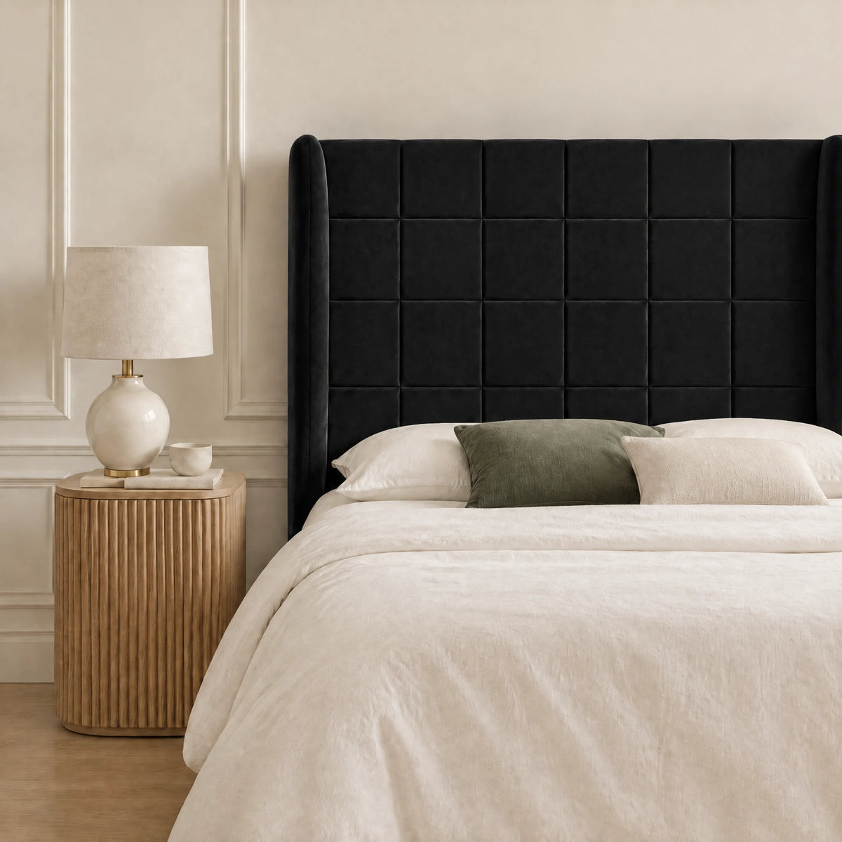 Tête de lit haute à oreilles en velours Trocadéro noir dans une chambre, avec table de chevet et lampe