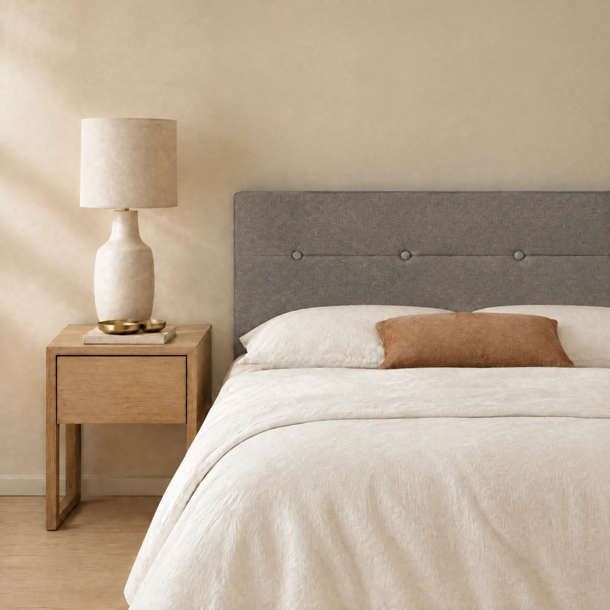 Tête de lit en tissu à poser Marais taupe dans une chambre, avec table de chevet et lampe
