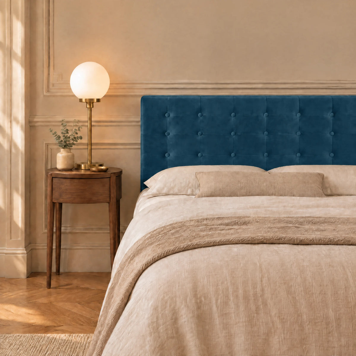 Tête de lit boutonnée en velours Dauphine bleu canard dans une chambre, avec table de chevet et lampe