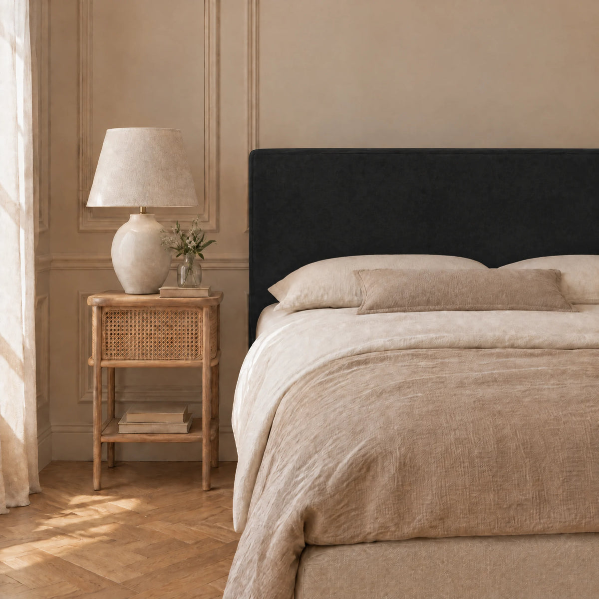Tête de lit en velours lisse Cluny noir dans une chambre, avec table de chevet et lampe