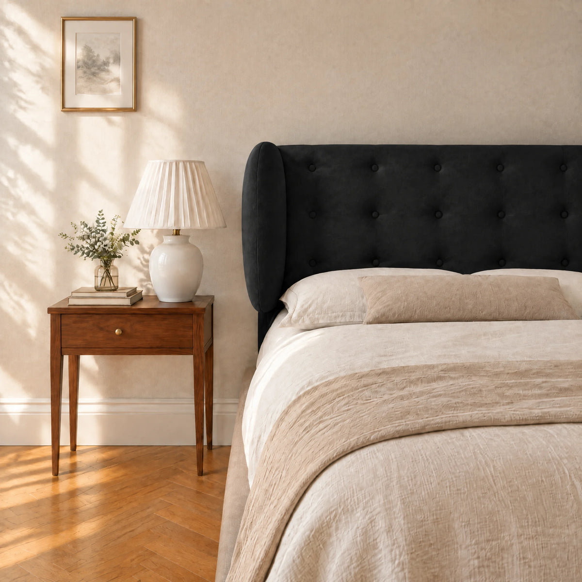 Tête de lit boutonnée à oreilles en velours Auteuil noir dans une chambre, avec table de chevet et lampe